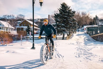 Un homme qui fait du fatbike dans les rues de Kamouraska. 